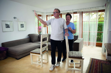 Ein Herr und eine Dame üben gemeinsam Übungen zur Sturzprävention